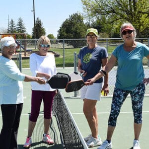 Photo of a Pickleball foursome on the court after the match